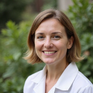 Portrait of a smiling female botanist, looking knowledgeable and approachable.